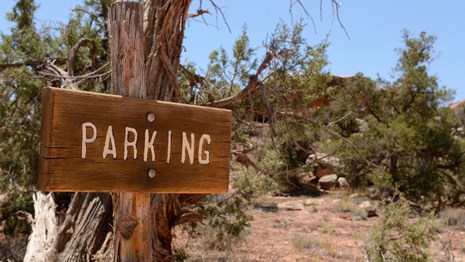 A wooden sign reads "parking" 