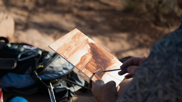a person paints in Canyonlands National Park