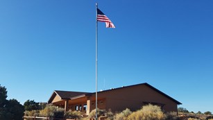 a tan building with an American flag flying outside