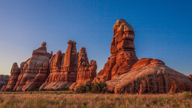 Rock spires glow orange in the afternoon light.