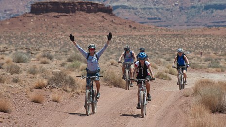 five bicyclists on an unpaved road