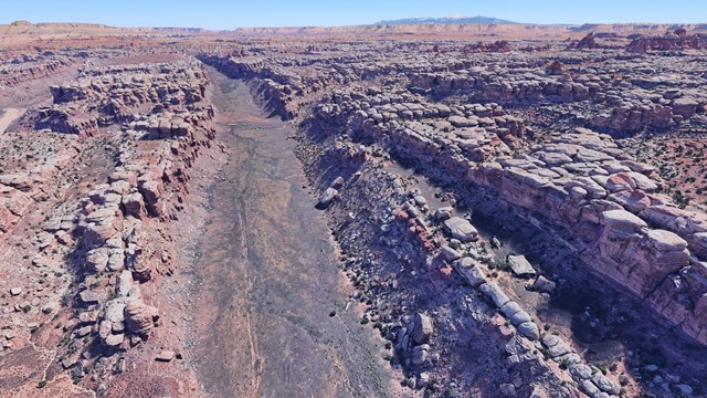 aerial photograph of a graben: a long, narrow, flat-bottomed valley between tan rock walls,