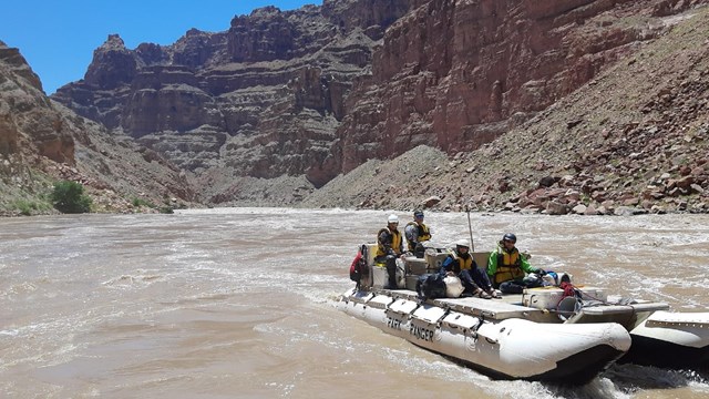 a white boat on a river with rapids