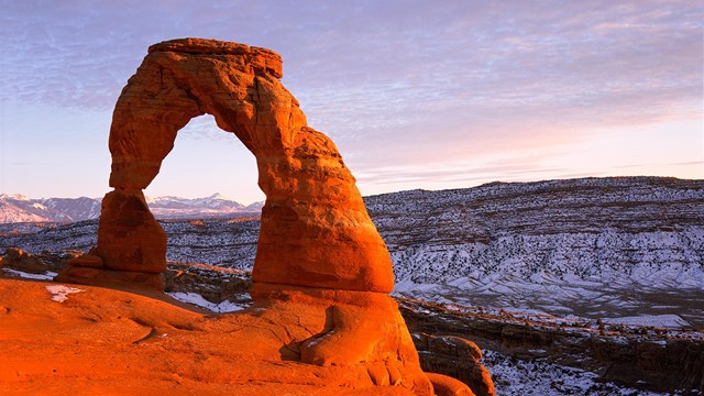 an arch glows red at dusk