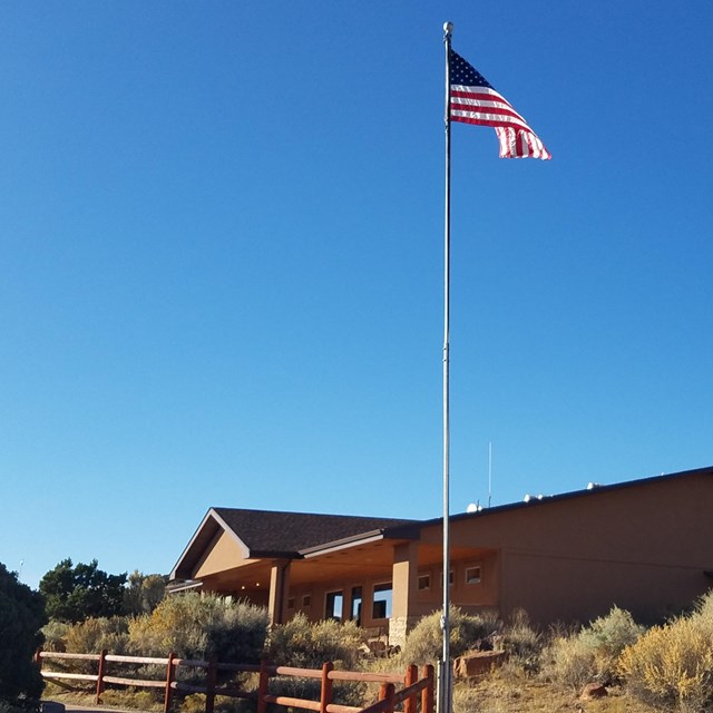 a tan building with an American flag flying outside