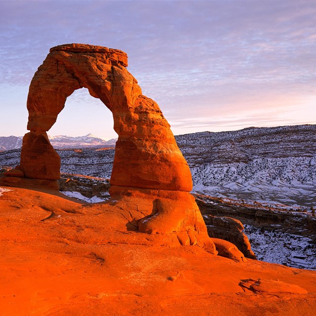 an arch glows red at dusk