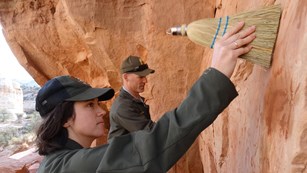 Park staff removing graffiti with water and brushes