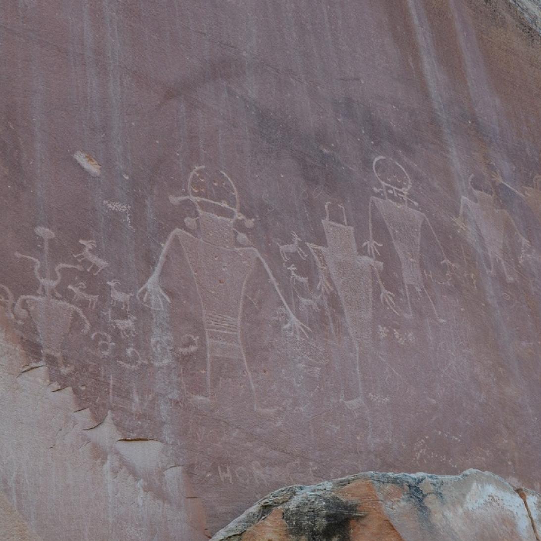 Petroglyphs of human-like figures in red sandstone.