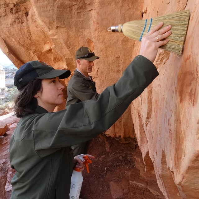 Park staff removing graffiti with water and brushes