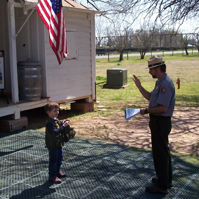 Ranger swearing in a child as a Jr. Ranger. 