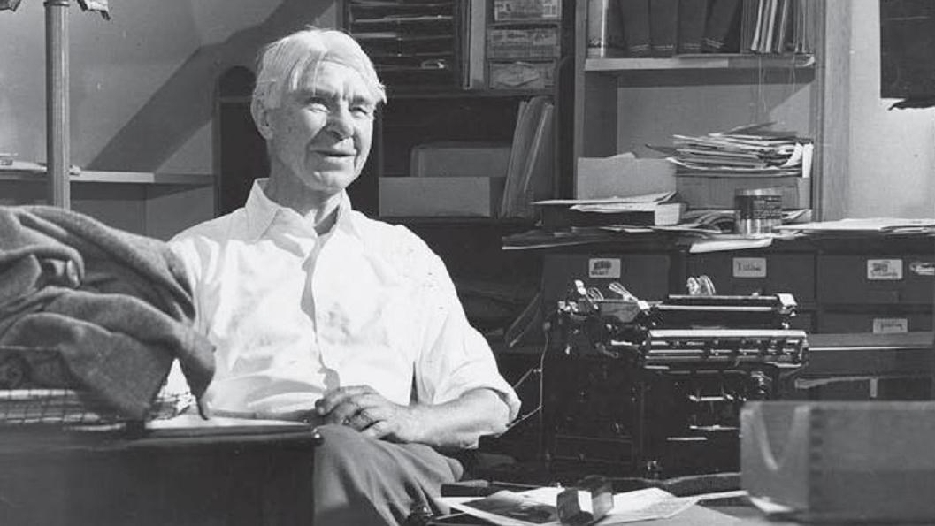 Black and white photo of Carl Sandburg at a desk