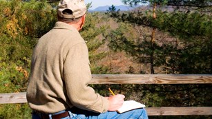 A writer is inspired by the scenery along a park trail.