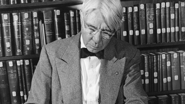 Image of Carl Sandburg holding a large book