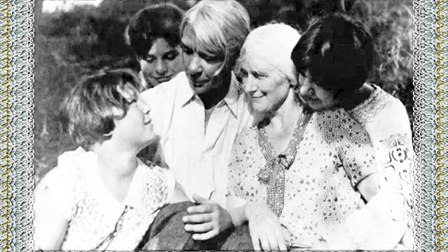 Black and white photo of Man, woman, and three children with paper background