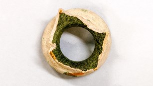 green and beige fragment of a pottery jar neck