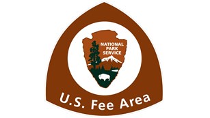 U.S. Fee area triangular sign with NPS Arrowhead centered