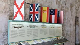 Exhibit pane with text and flags in fort's casemate. 