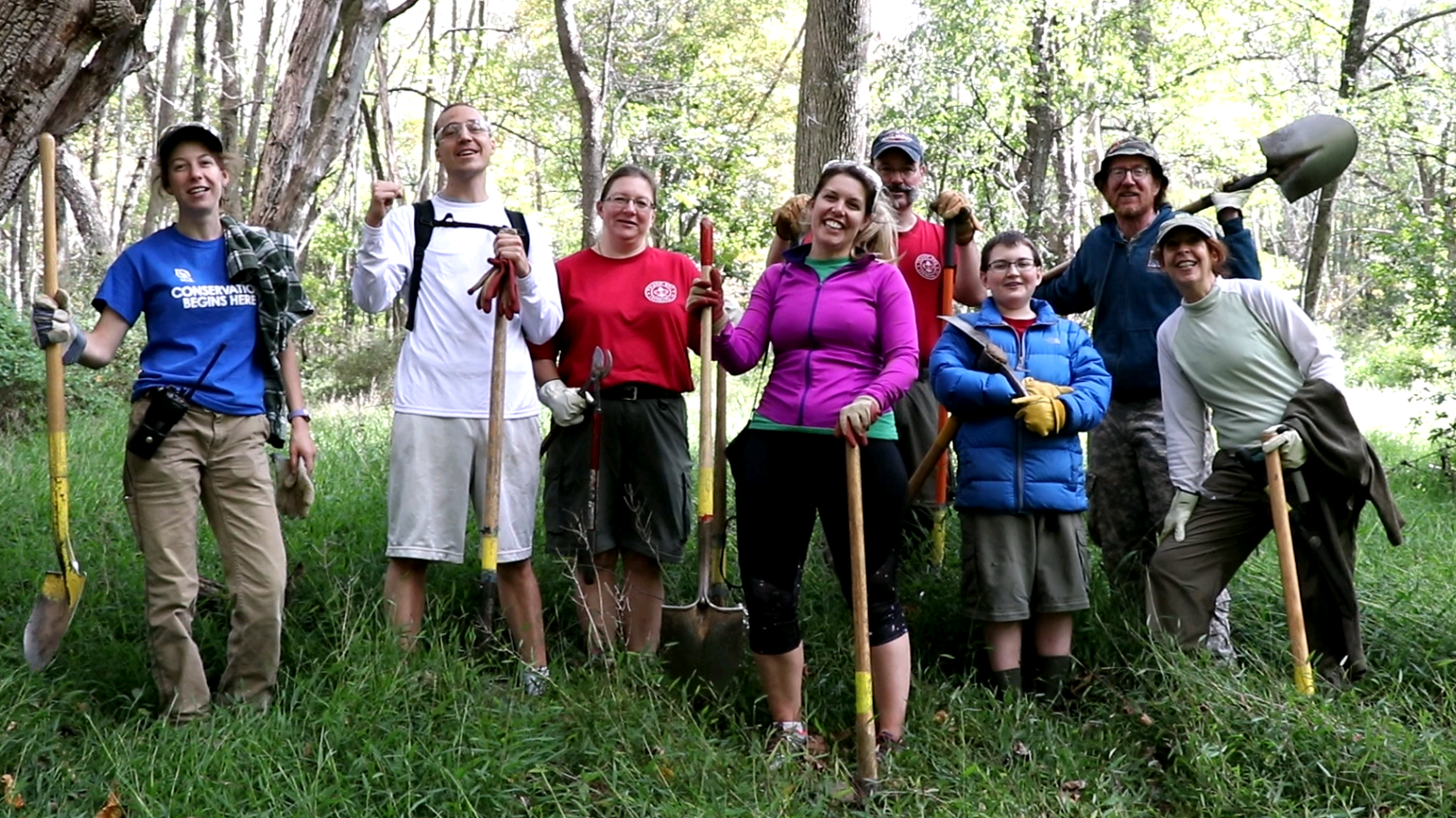 A volunteer crew poses with tools after a day of work.