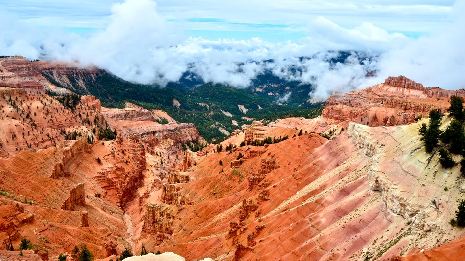 Orange and red rock formations form giant walls of a canyon extending away from the camera.