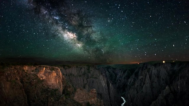 The milky way stretches across the sky above Black Canyon of the Gunnison