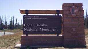 Stone and wood sign for Cedar Breaks National Monument. 