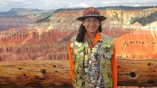 Girl with over 300 junior ranger badges posing at the Point Supreme Amphitheater.