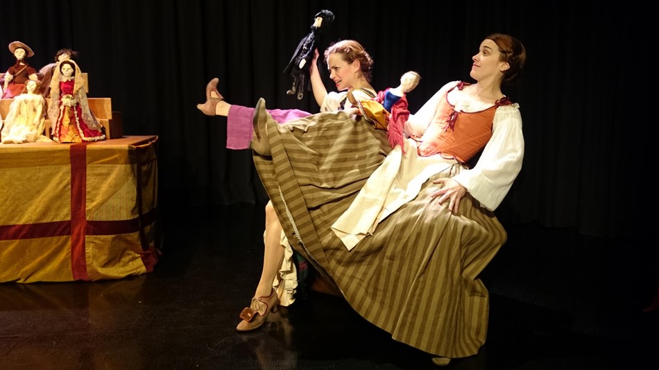 two actresses in Spanish Golden Age period costumes onstage in mid scene