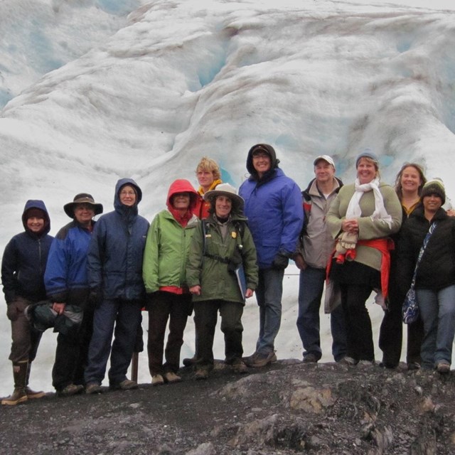 Large group of adults with Ranger in front of a glacier