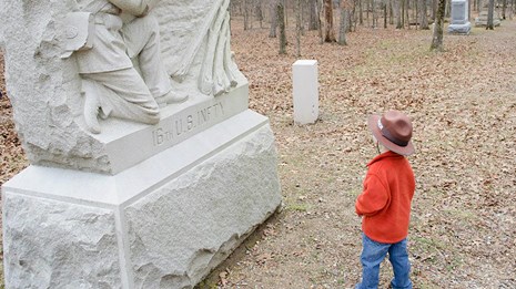 A junior ranger visits a monument in the battlefield