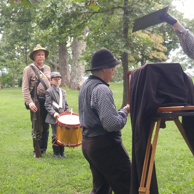 Living historians pose for a tintype photograph