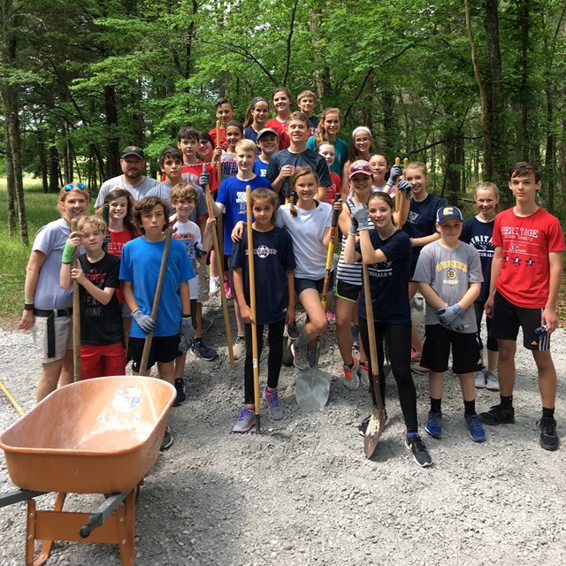 A group of young people holding shovels