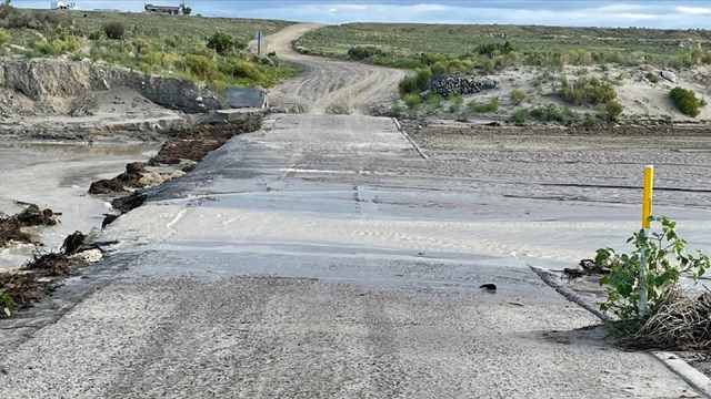 Water washing over a section of road.