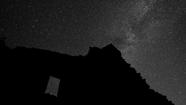 The top part of a sandstone wall and the bright stars overhead.