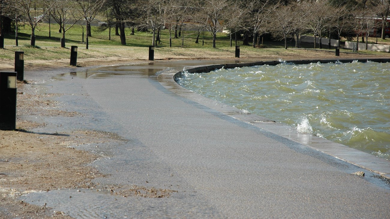 Water lapping over the concrete at the edge of the Tidal Basin