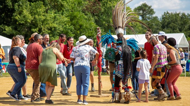 Group dancing with traditional dancer at an outdoor event