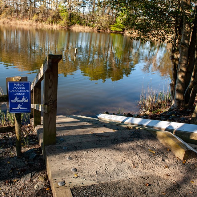 A kayak launch runs next to a set of stairs leading to water.