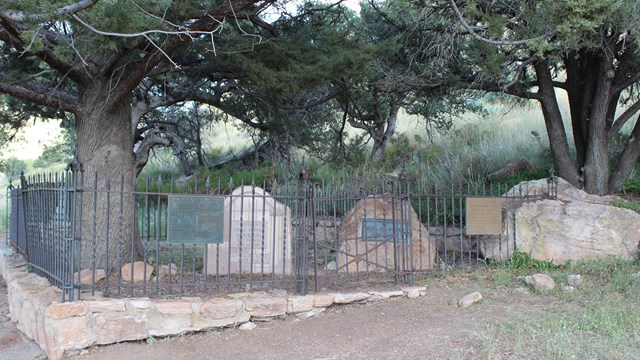 Photo of small cemetery under some trees. 