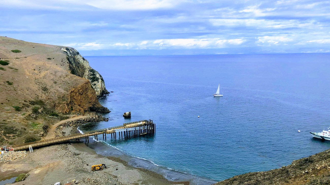 pier in achorage surrounded by steep ocean cliffs. 
