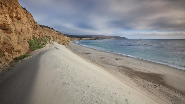 White sand dune with blue water. ©Tim Hauf, timhaufphotography.com