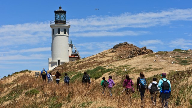 Visitor hiking to a lighthouse. ©Tim Hauf, timhaufphotography.com