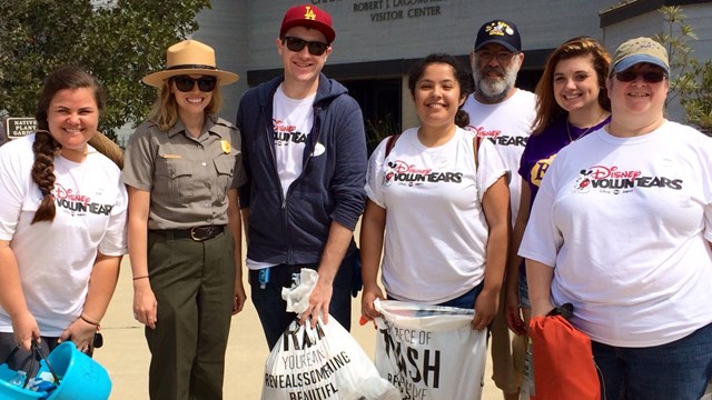 Volunteers holding beach clean up bags. 