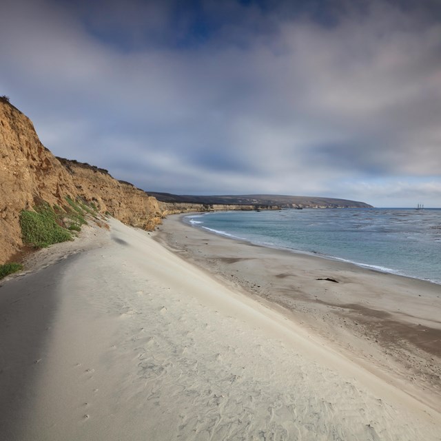 White beach dune next to bluff and ocean. ©Tim Hauf, timhaufphotography.com