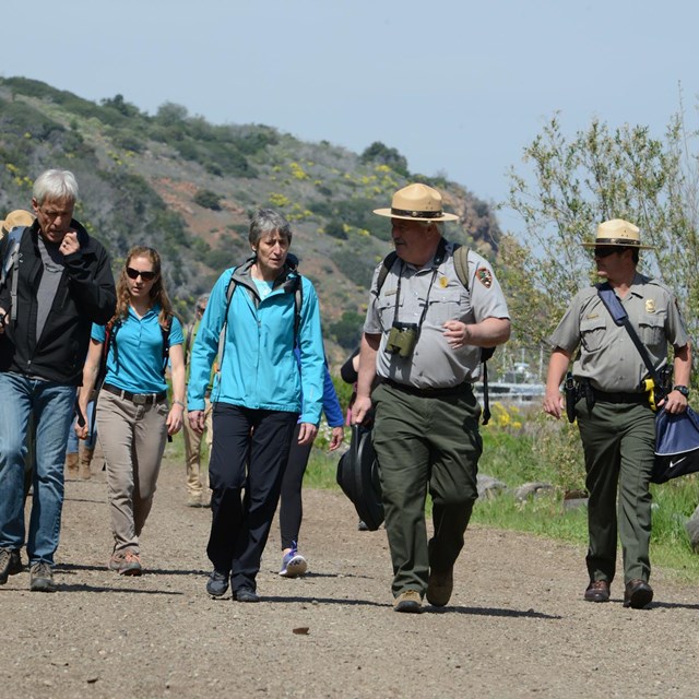 rangers and visitors walking along a path. 