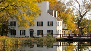 Great Falls Tavern Visitor Center in autumn reflecting in the watered canal. 