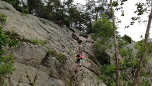 Visitors hiking up the 40 foot traverse on Billy Goat Section A trail.