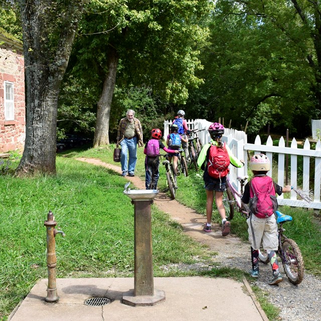 Cyclists passing a lockhouse next to the canal