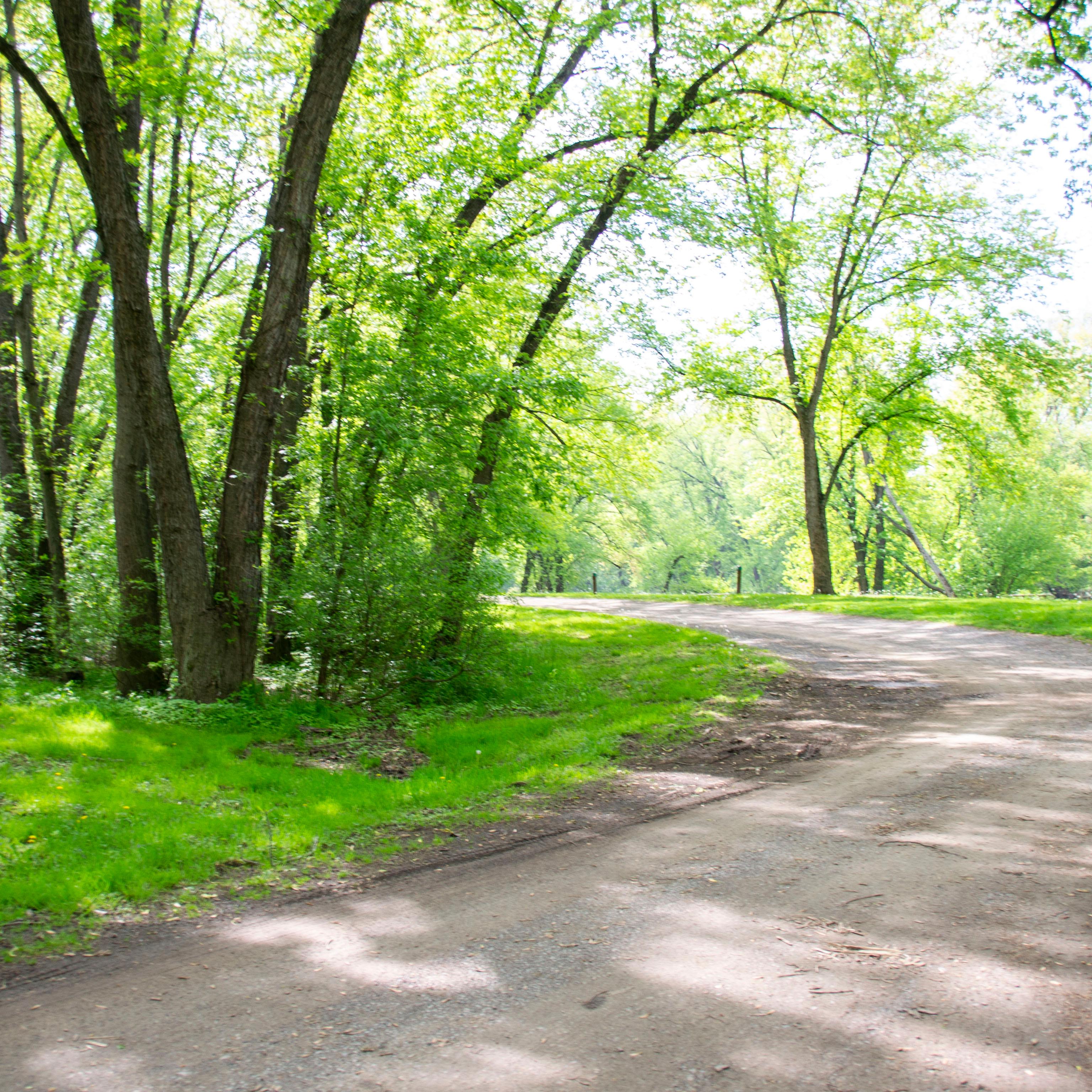 The towpath wraps around trees to a campground.