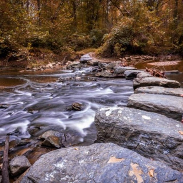 Flowing water over riverbed of rocks.