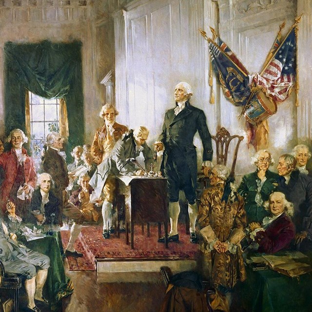 Delegates, and George Washington, cheer as they sign the Constitution.