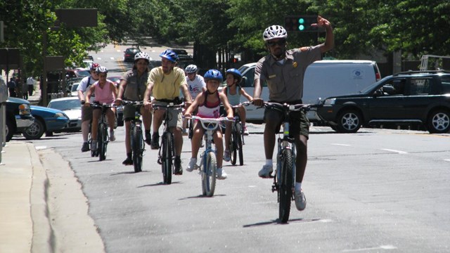 A park ranger leads a group on a bicycle tour of Little Rock.